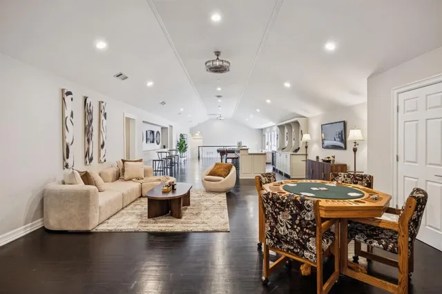 a living room with furniture kitchen view and a wooden floor