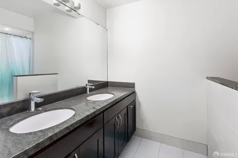 a bathroom with a granite countertop sink and a mirror