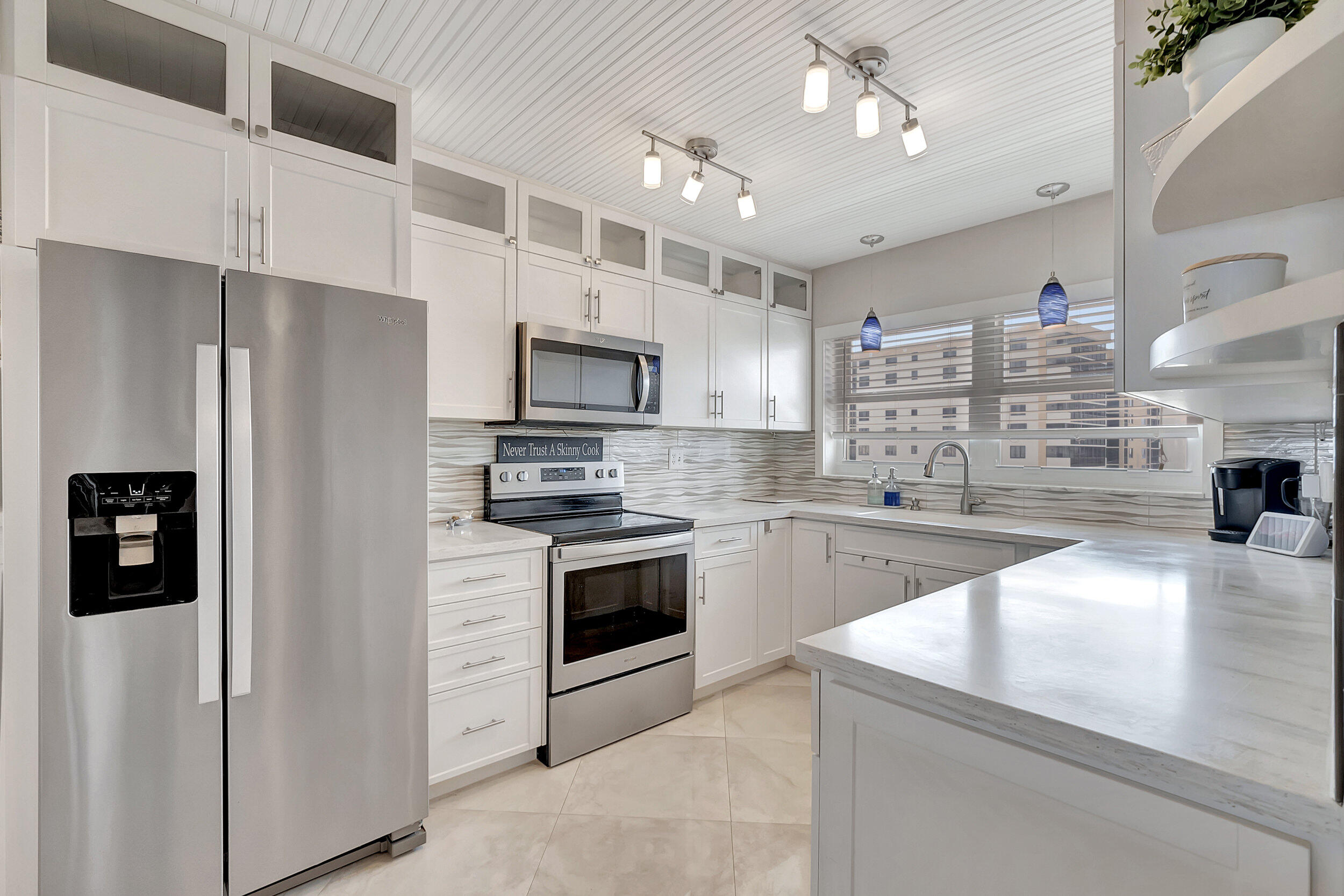 a kitchen with kitchen island a counter top space stainless steel appliances and cabinets