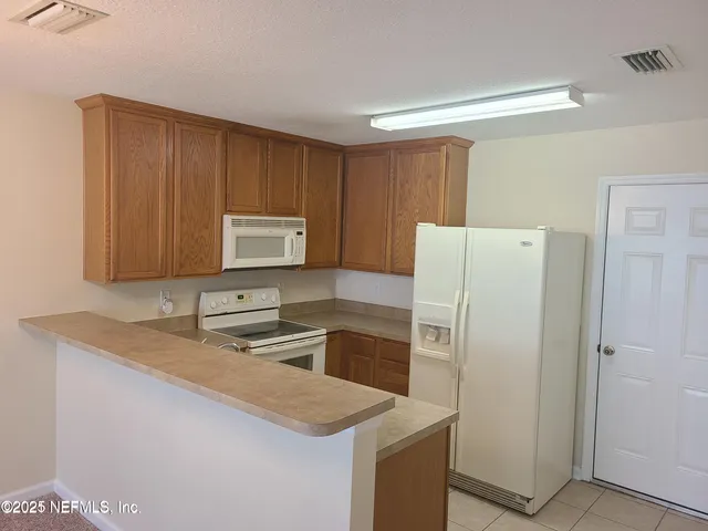 a kitchen with a sink a stove a refrigerator and a microwave