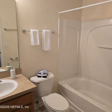 a bathroom with a granite countertop sink a toilet and a bathtub