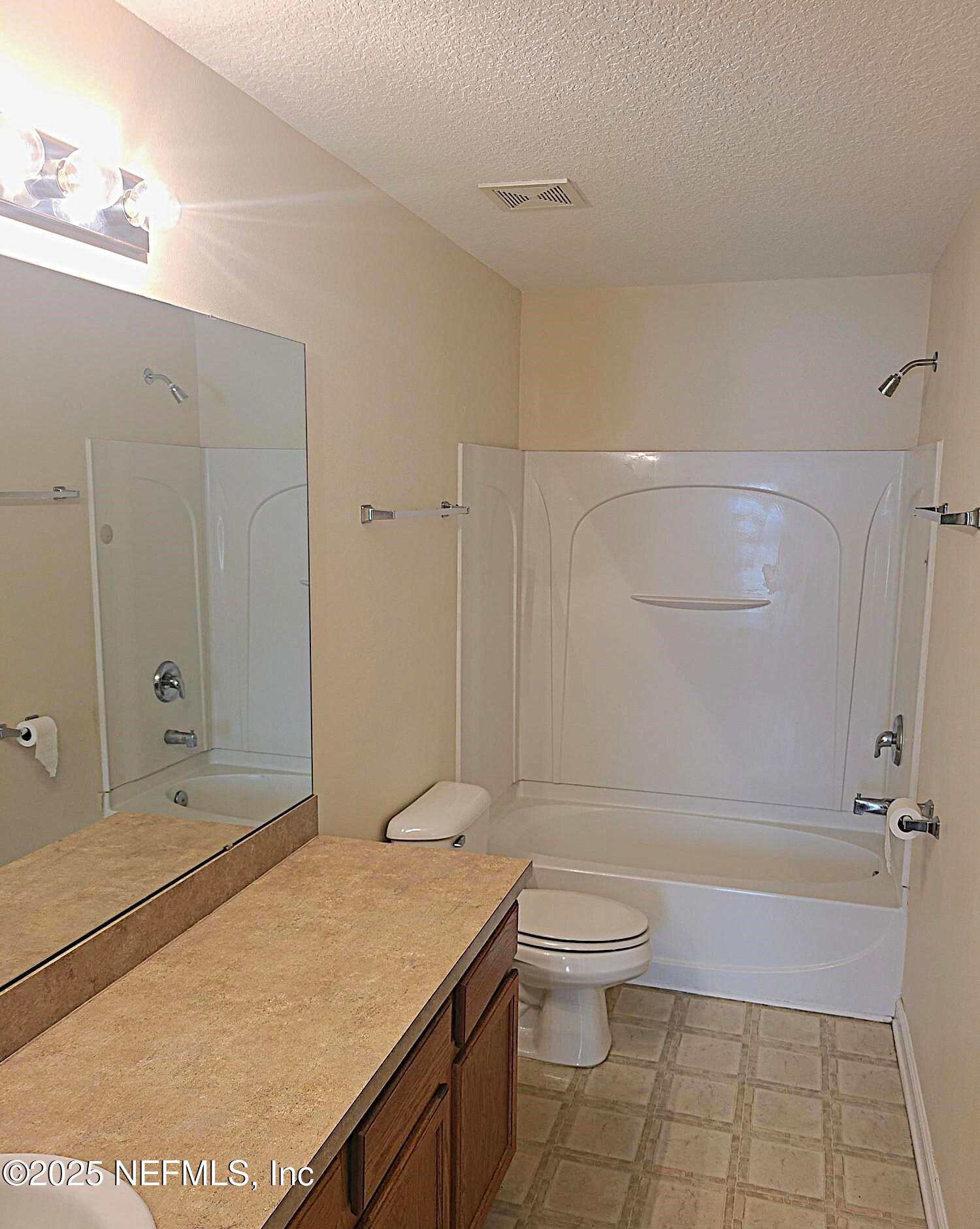 1500 Calming Water Drive, Unit 5703 Fleming Island, FL 32003 - Photo 8 of 17 a bathroom with a granite countertop sink a toilet and shower