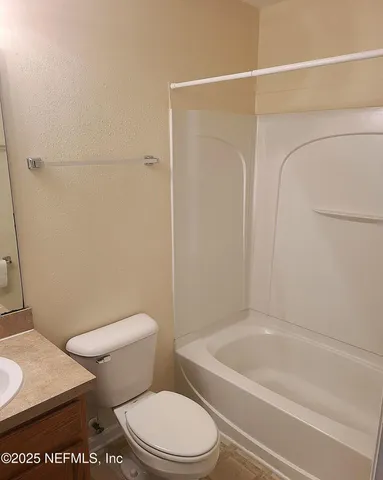 a white toilet sitting next to a bath tub