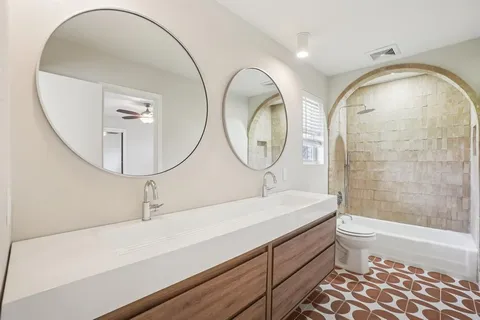 a bathroom with a sink a toilet and a mirror