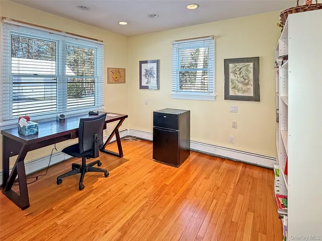a view of a workspace with furniture and a window