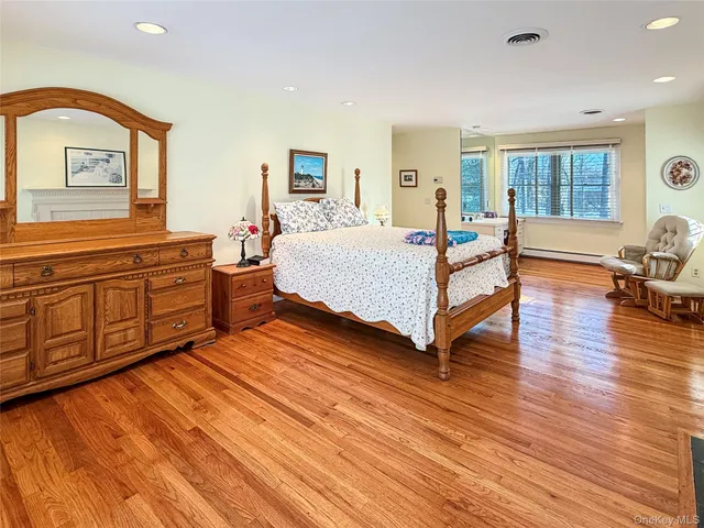 a spacious bedroom with a bed and wooden floor
