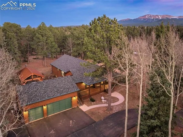 an aerial view of a house with a mountain