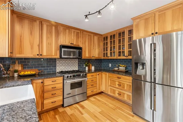 a kitchen with stainless steel appliances granite countertop a refrigerator stove top oven and sink