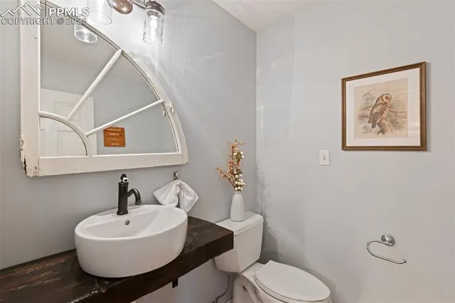 a bathroom with a toilet a sink and mirror