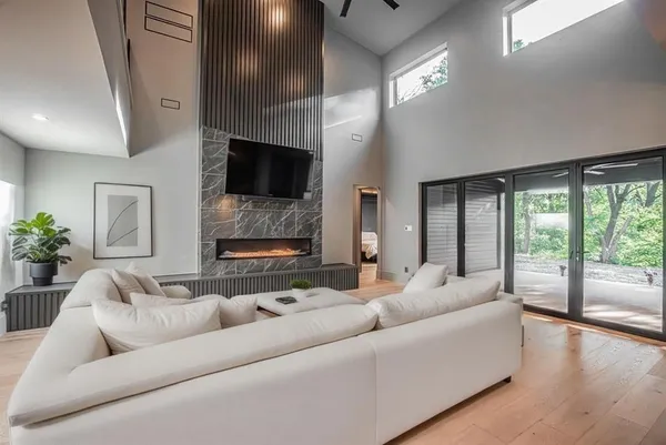 a living room with furniture a large window and a flat screen tv