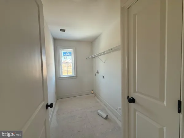 a view of an empty room with window and bathroom