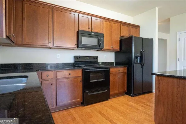 a kitchen with stainless steel appliances granite countertop a refrigerator stove and microwave
