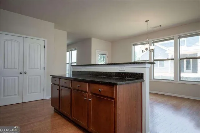 a kitchen with stainless steel appliances granite countertop a stove a sink and a microwave