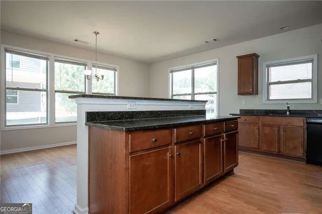 a kitchen with stainless steel appliances granite countertop a stove a sink and a microwave