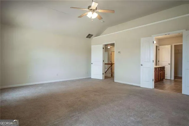 an empty room with closet and a chandelier fan