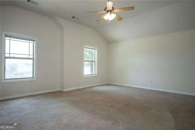 an empty room with a window and a fan