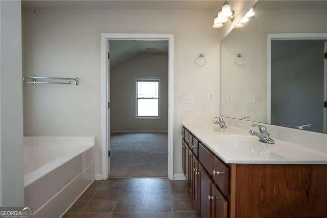 a bathroom with a sink vanity tub and a mirror
