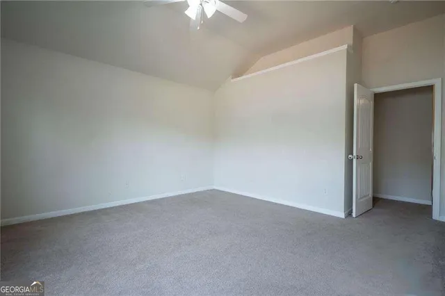 an empty room with a chandelier fan