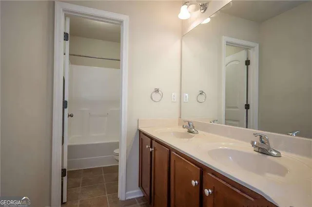 a bathroom with a double vanity sink mirror and shower