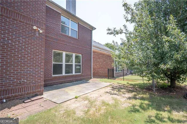 a view of a house with backyard and trees