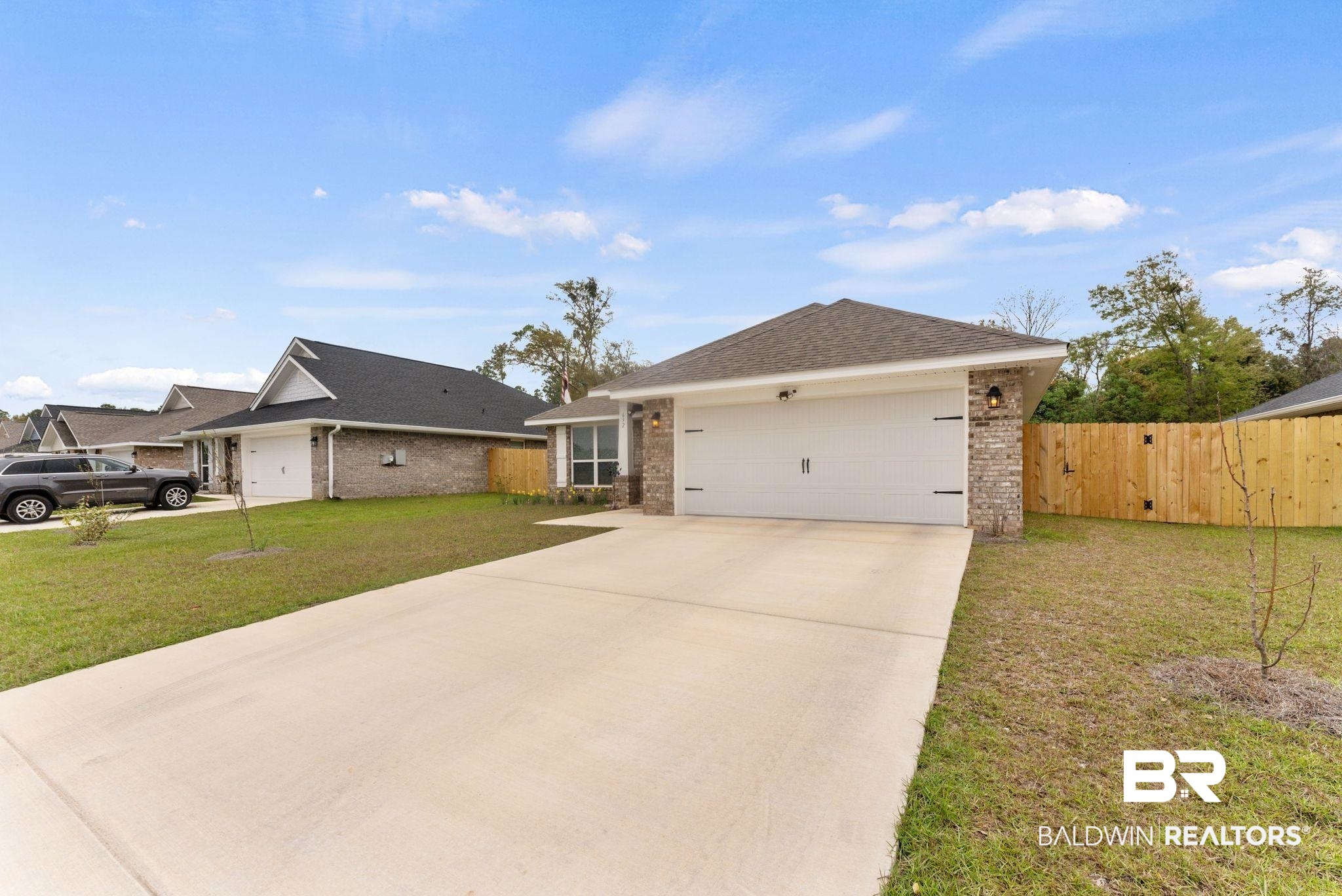692 Mayflower Drive Foley, AL 36535 - Photo 3 of 40 Ranch-style house featuring a garage, driveway, brick siding, and roof with shingles