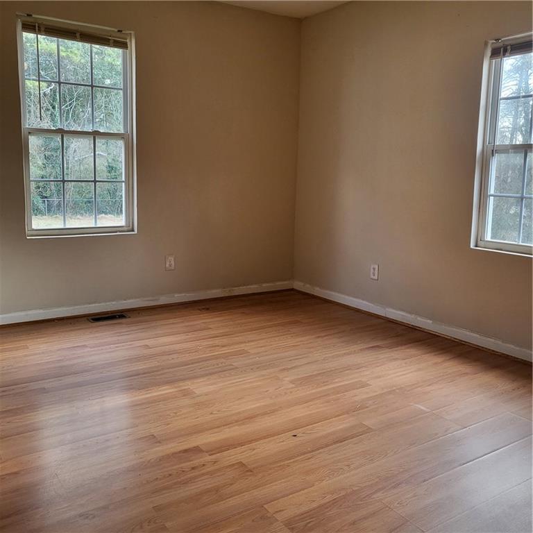 592 Allgood Road Stone Mountain, GA 30083 - Photo 2 of 14 an empty room with wooden floor and windows