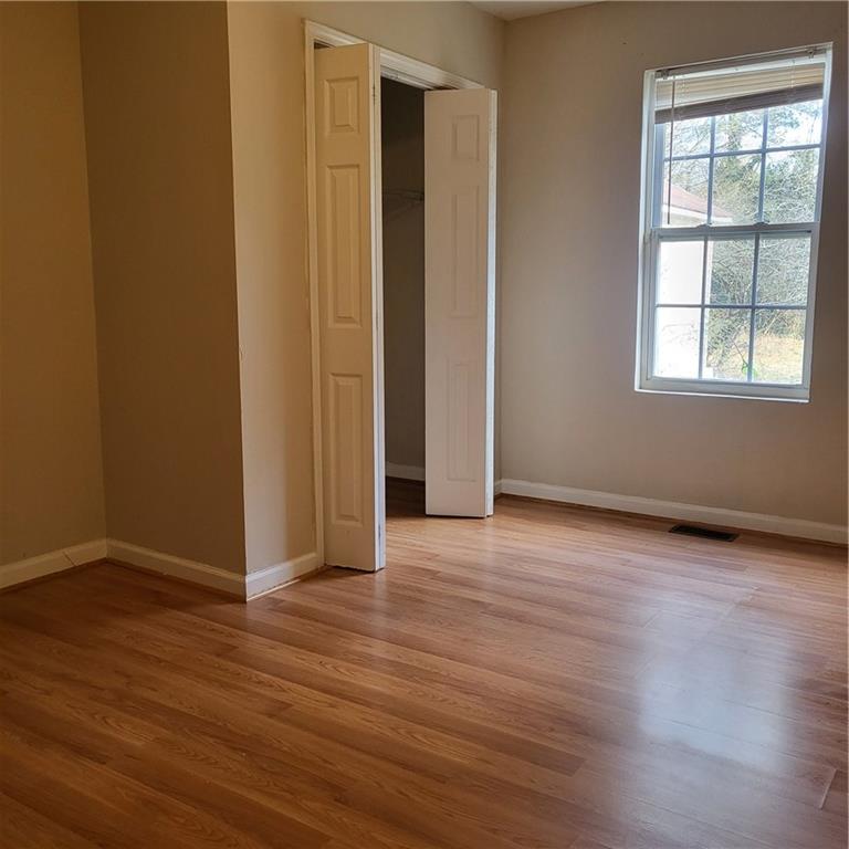 592 Allgood Road Stone Mountain, GA 30083 - Photo 3 of 14 an empty room with wooden floor and windows