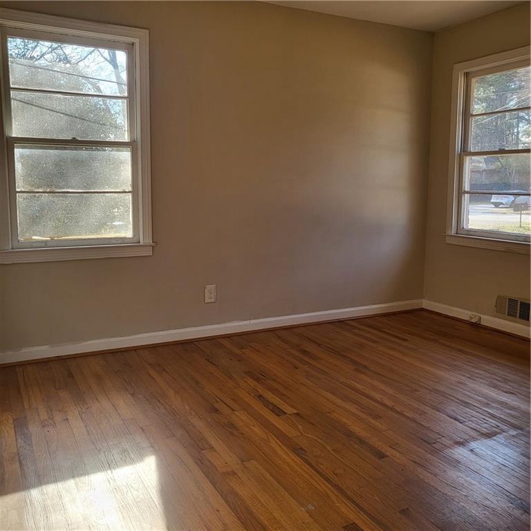 592 Allgood Road Stone Mountain, GA 30083 - Photo 4 of 14 a view of an empty room with wooden floor and a window