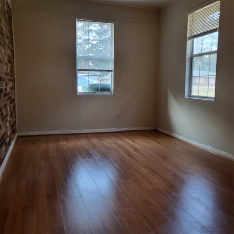 592 Allgood Road Stone Mountain, GA 30083 - Photo 5 of 14 an empty room with wooden floor and windows
