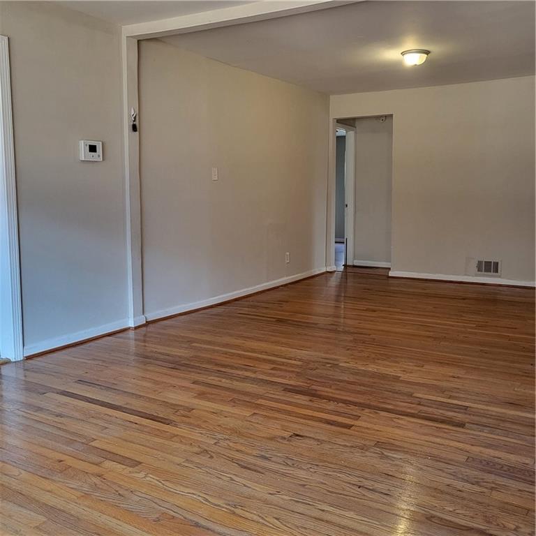 592 Allgood Road Stone Mountain, GA 30083 - Photo 8 of 14 a view of an empty room with wooden floor and a window
