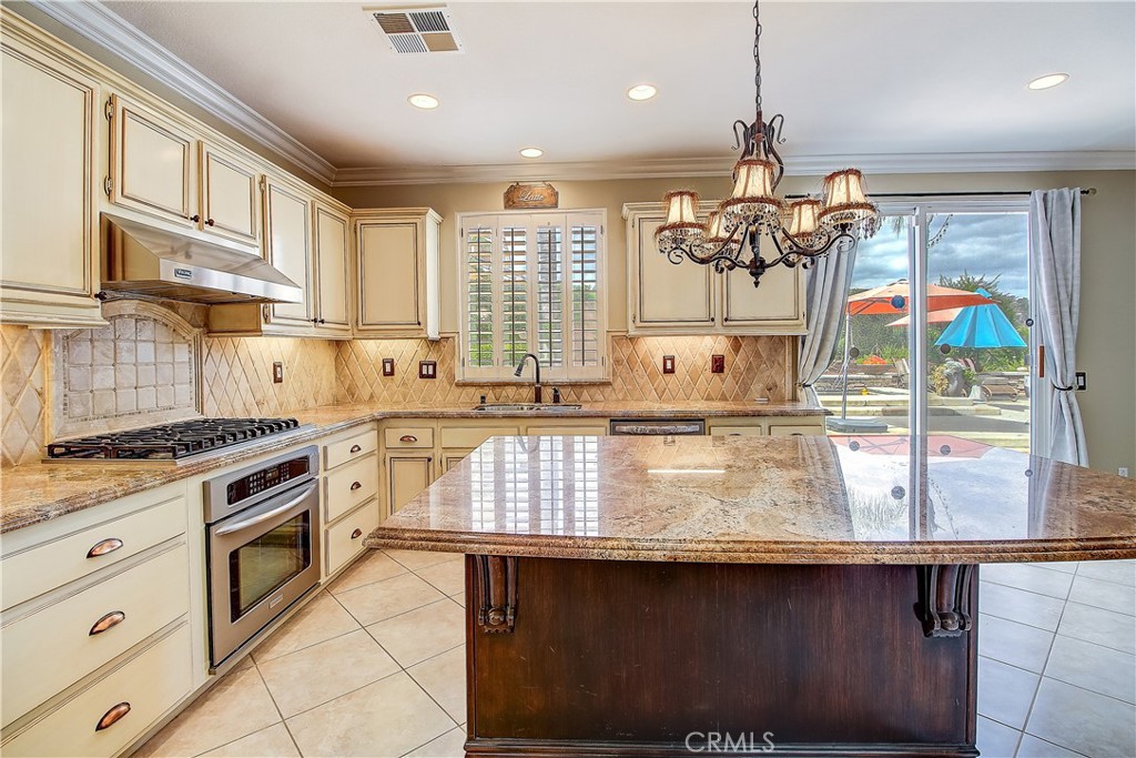 14182 Crystal View Terrace Riverside, CA 92508 - Photo 26 of 74 a kitchen with granite countertop a sink stove and cabinets