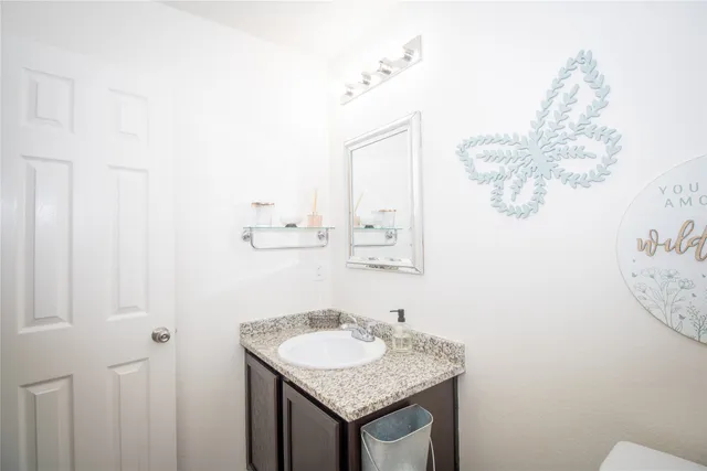 a bathroom with a granite countertop sink and a mirror