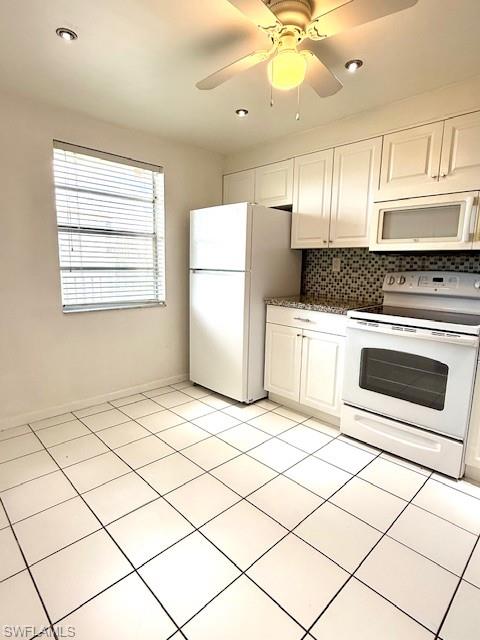 3910 Inverrary Boulevard, Unit 407B Lauderhill, FL 33319 - Photo 7 of 28 a kitchen with a stove a refrigerator and white cabinets