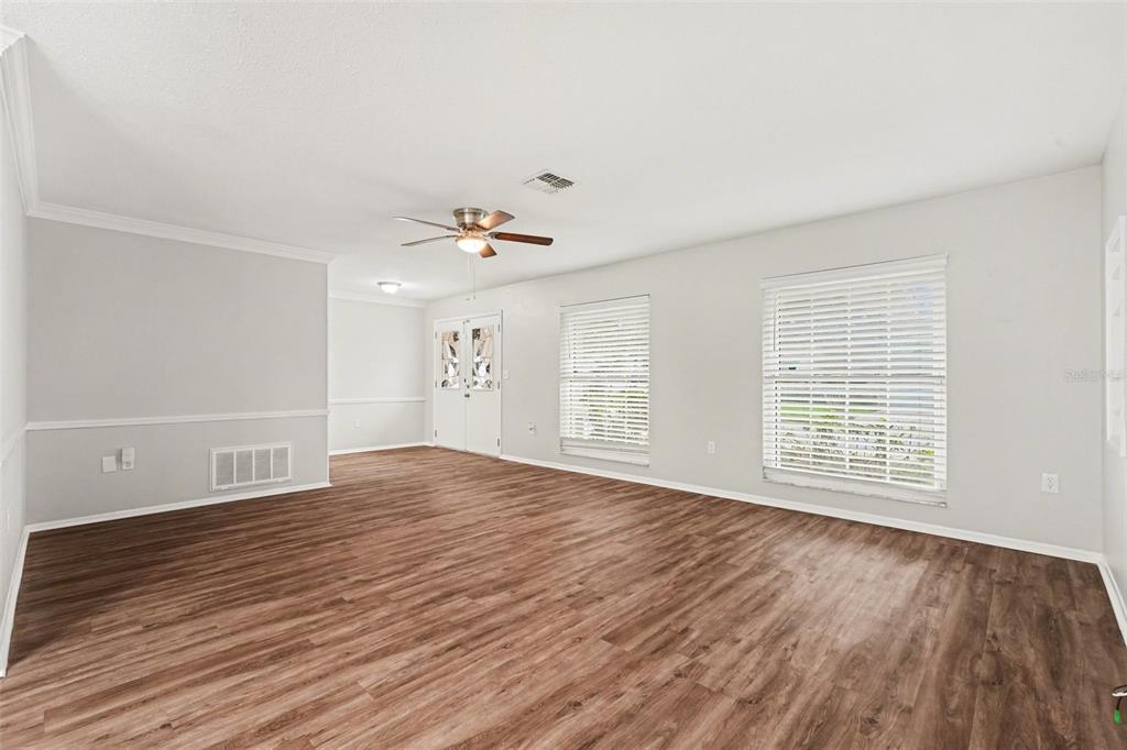8103 Roxboro Drive Hudson, FL 34667 - Photo 14 of 28 a view of an empty room with wooden floor and a window