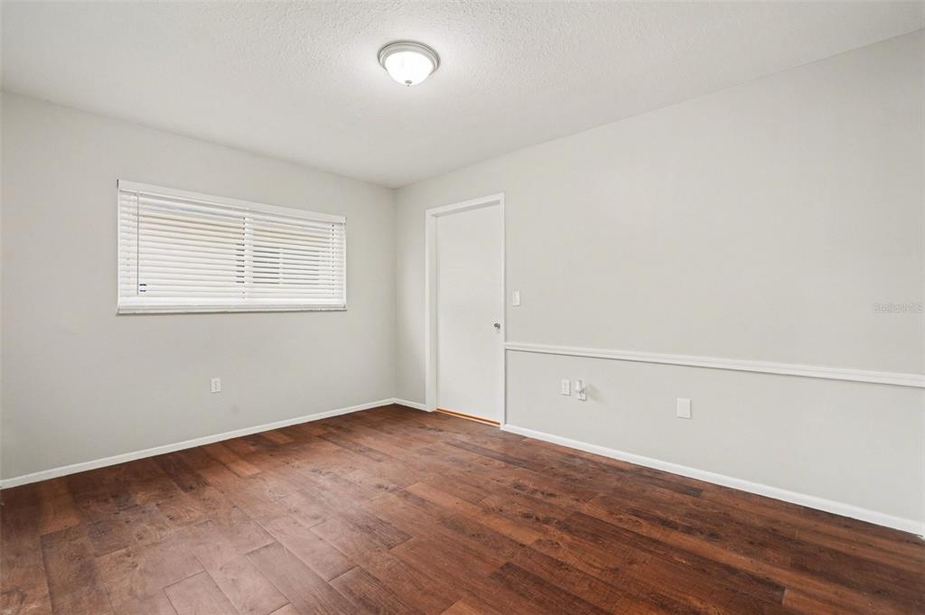 8103 Roxboro Drive Hudson, FL 34667 - Photo 19 of 28 an empty room with wooden floor and windows