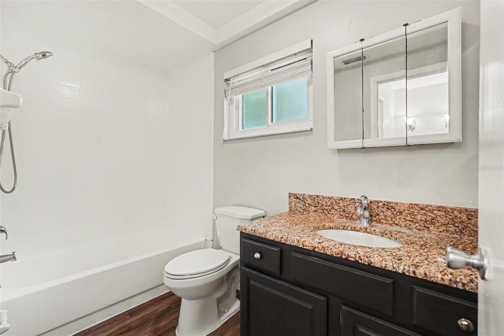 8103 Roxboro Drive Hudson, FL 34667 - Photo 23 of 28 a bathroom with a granite countertop sink a toilet and shower