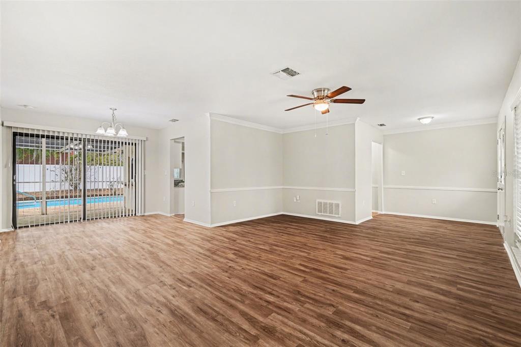 8103 Roxboro Drive Hudson, FL 34667 - Photo 4 of 28 wooden floor in an empty room with a ceiling fan