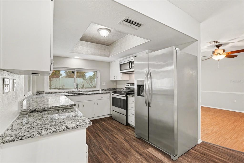 8103 Roxboro Drive Hudson, FL 34667 - Photo 7 of 28 a kitchen with stainless steel appliances granite countertop a refrigerator and a sink
