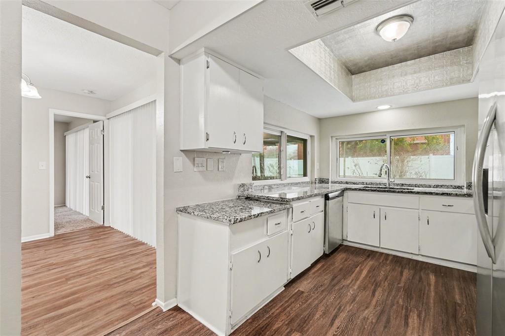 8103 Roxboro Drive Hudson, FL 34667 - Photo 8 of 28 a kitchen with granite countertop white cabinets and white appliances