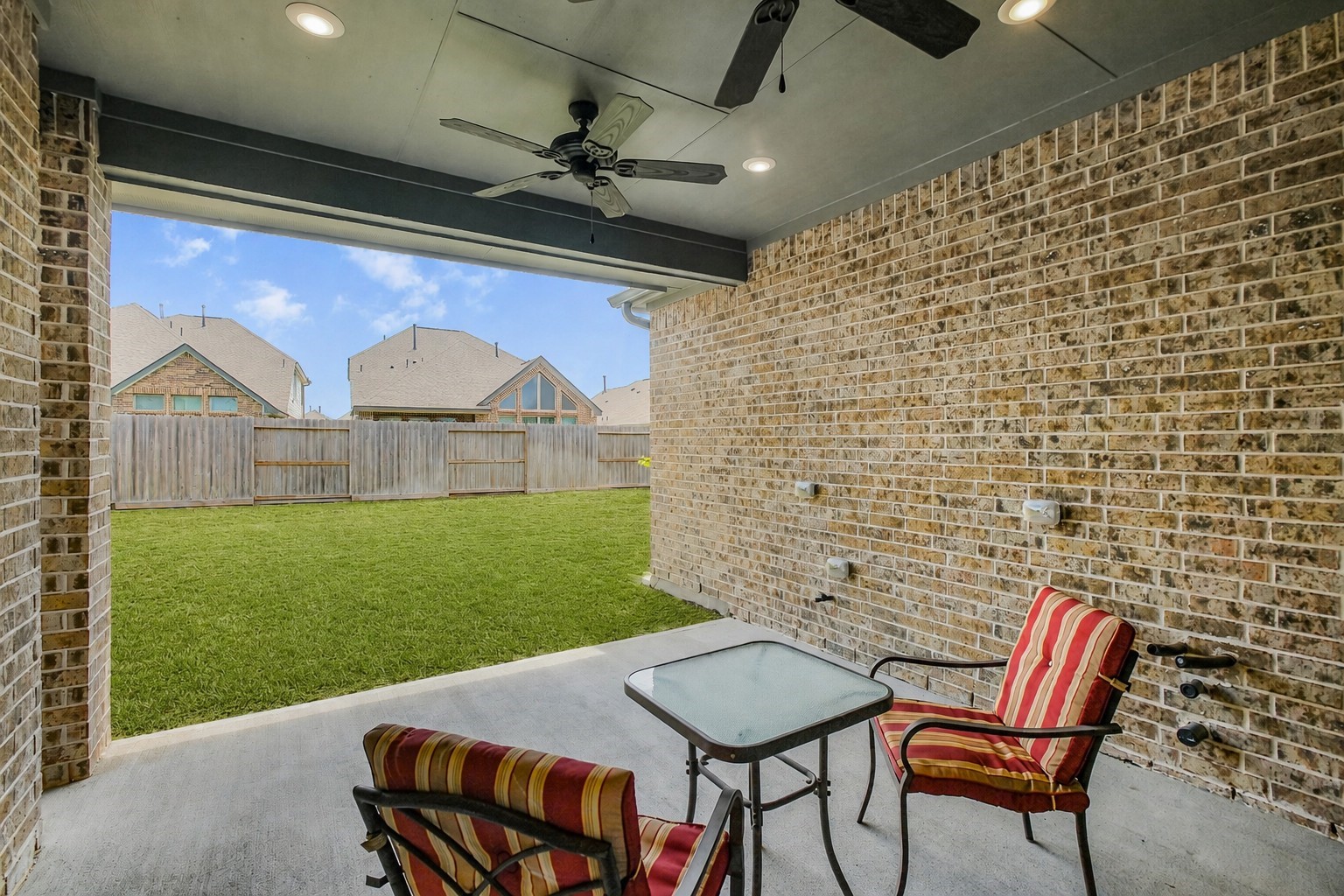 10514 Rigel Rdg Way Richmond, TX 77406 - Photo 44 of 50 Now let’s head back downstairs and step outside! The spacious covered patio features recessed lighting and dual ceiling fans, creating a comfortable spot for outdoor dining and relaxing.
