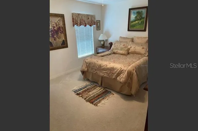a large bed sitting in a bedroom next to a cabinet with a rug