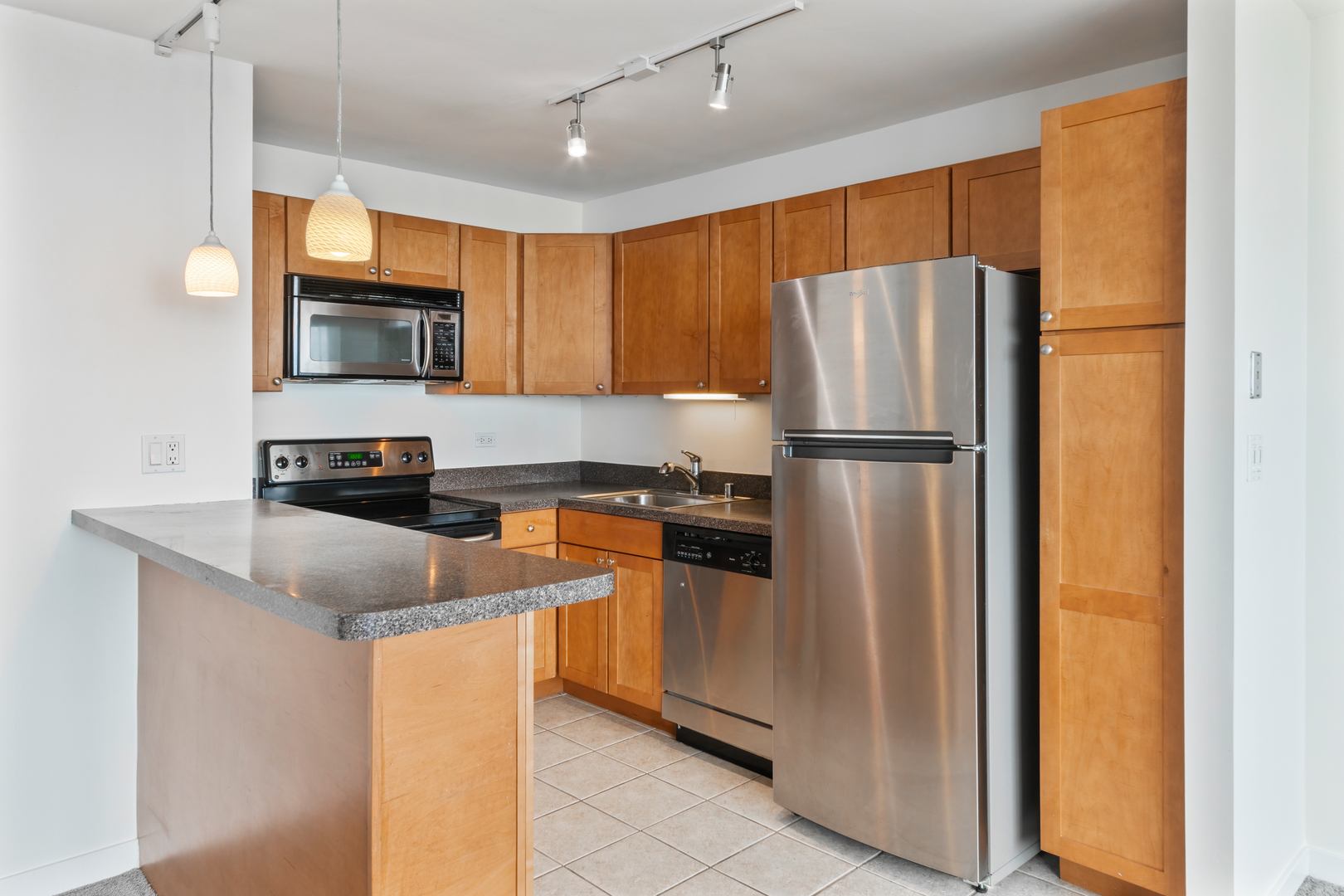 655 West Irving Park Road, Unit 4808 Chicago, IL 60613 - Photo 8 of 26 a kitchen with stainless steel appliances granite countertop a refrigerator a stove a sink and a microwave