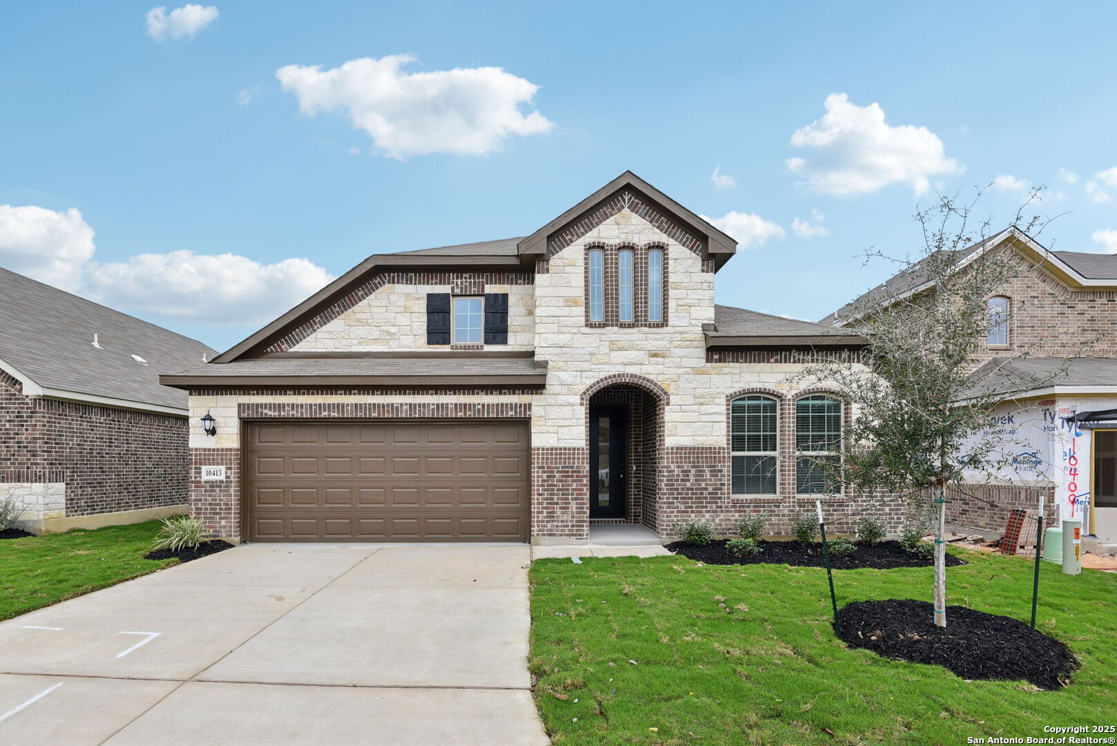 a front view of a house with a yard and garage