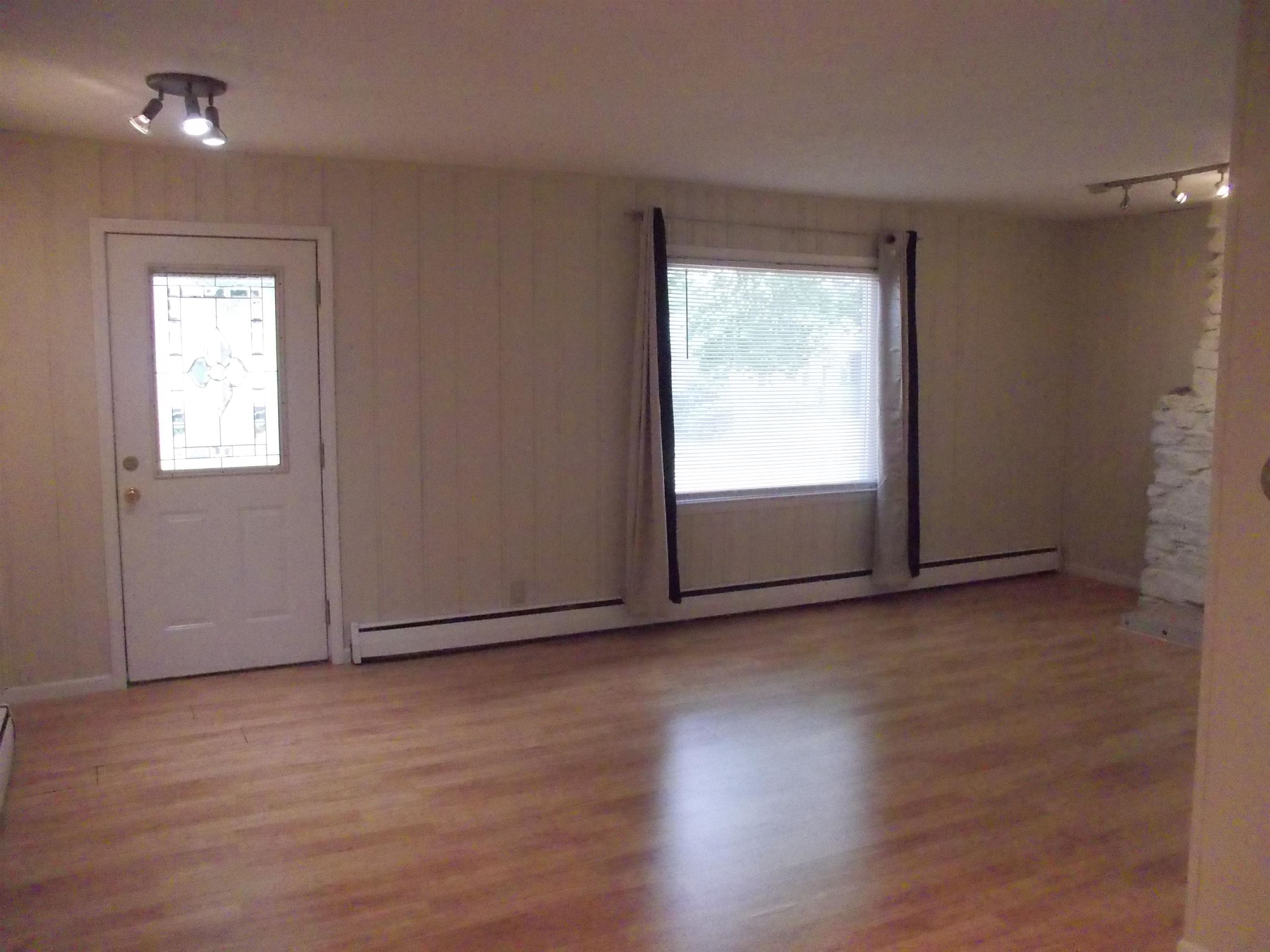 724 Taft Road Rockford, IL 61109 - Photo 6 of 19 an empty room with wooden floor and windows
