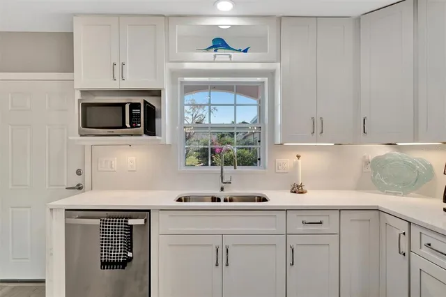 a kitchen with stainless steel appliances a sink stove and microwave