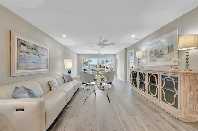 a living room with stainless steel appliances granite countertop furniture and a wooden floor