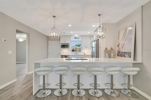 a kitchen with stainless steel appliances kitchen island granite countertop a table and chairs