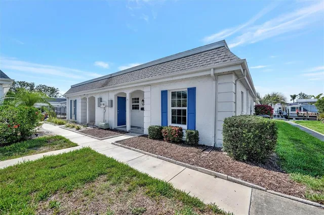 a front view of a house with a yard and potted plants