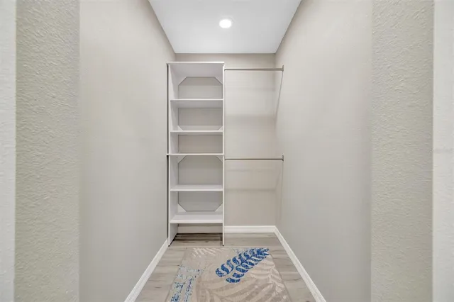 a view of walk in closet with empty racks