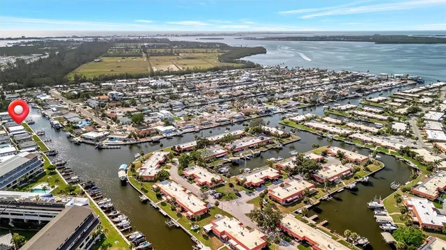 an aerial view of ocean and residential houses with outdoor space